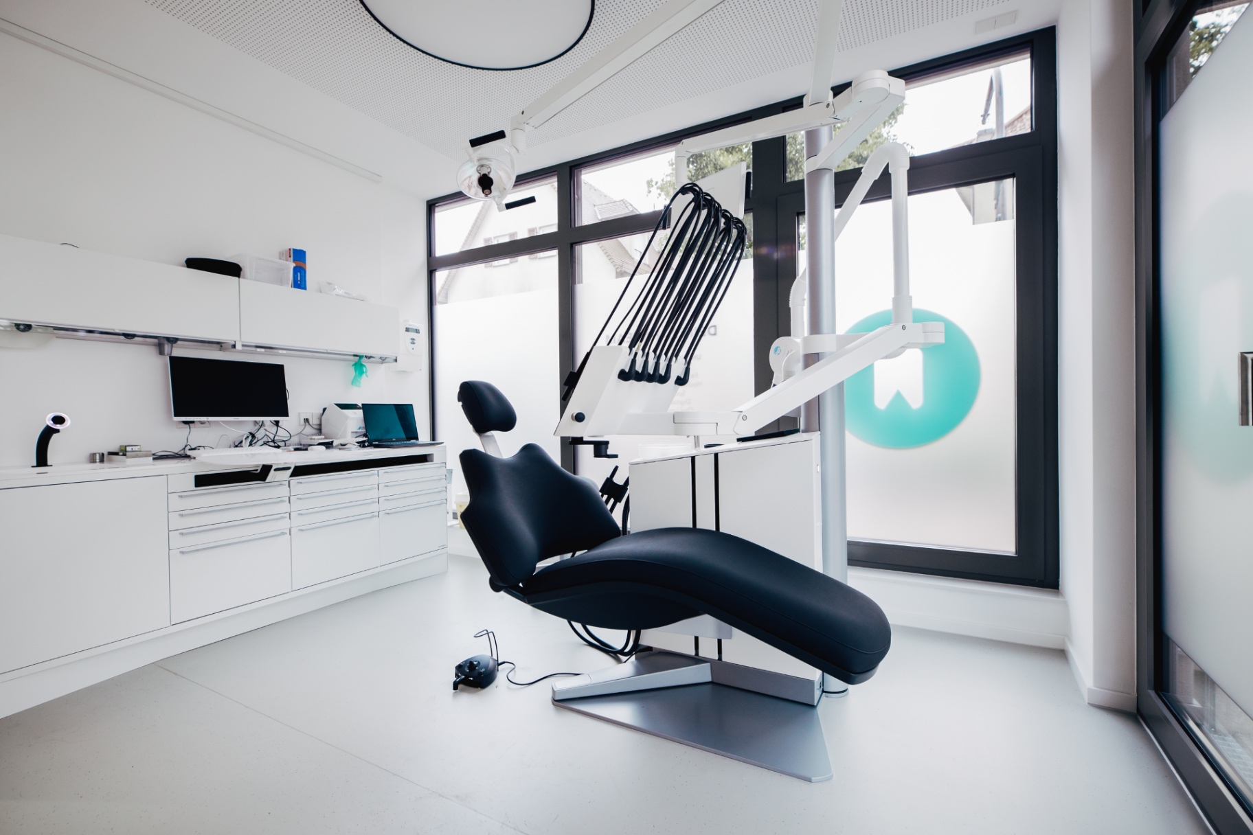 Behandlungszimmer mit Tageslicht und ZAHNTEAM-Logo am Fenster